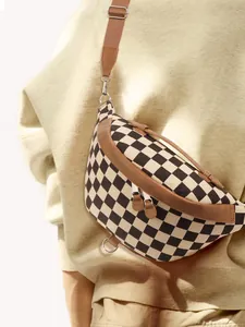 Close-up of checkerboard sling bag with brown leather trim and metal dual zippers