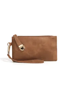Detail view of brown vintage wristlet wallet with gold zipper and textured leather finish