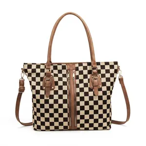 Black and white checkerboard tote bag with dual zippers and brown leather handles