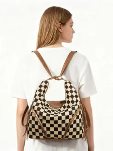 Detail of checkered backpack with brown leather straps and side metal zipper accents