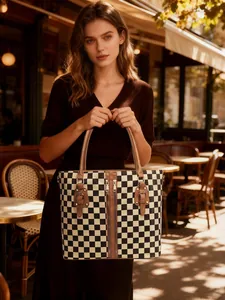 Outdoor shot of a checkerboard tote bag with brown leather handles and zipper details