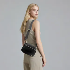 Rückansicht einer schwarzen Nylon-Umhängetasche mit goldener Hardware und verstellbarem Gurt