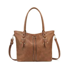 Detailed front view of brown leather tote bag with parallel zippers and gold rivets
