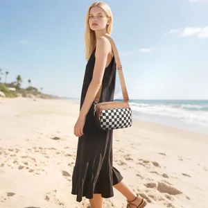Fashionable checkerboard crossbody bag with brown leather trim and wide adjustable strap