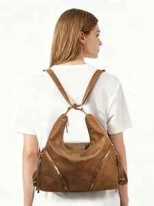 Rear view of model wearing a vintage brown PU leather backpack with diagonal zippers