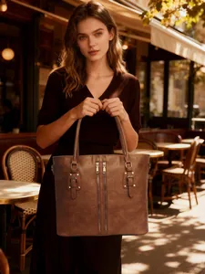 Close-up of vintage brown leather tote bag with stylish zipper and buckle details