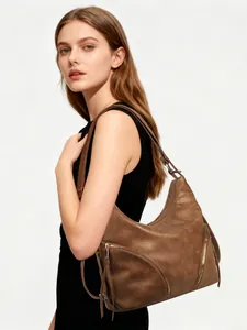 Detailed side view of a large brown faux leather tote bag with stylish diagonal zippers