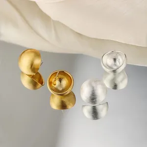 Orecchini a lobo a cupola satinata in oro e argento su elegante sfondo di seta beige