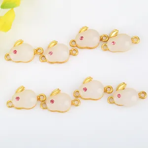 Detail of bunny charm connectors with white jade-like stone and gold-plated dual loops