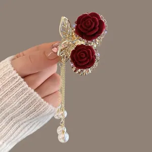 Detail of red velvet rose hair claw with sparkling rhinestones and pearl tassels