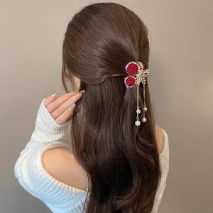 Detailed view of red velvet roses, crystal butterfly and long pearl tassels on hair claw