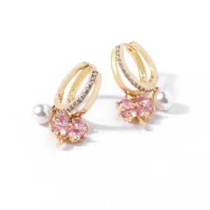 Dettaglio orecchini a fiore dorati con quadrifoglio in zircone rosa e perle bianche