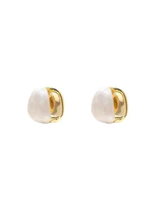 Detailed close-up of semi-spherical gold plated hoop earrings with white pearlescent finish