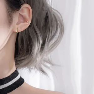 Ensemble de boucles d'oreilles Mobius torsadées dorées portées sur l'oreille