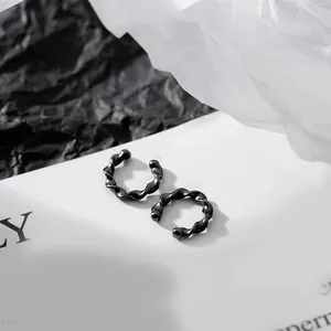 Détail du clip d'oreille noir torsadé montrant le design ondulé et la texture haut de gamme