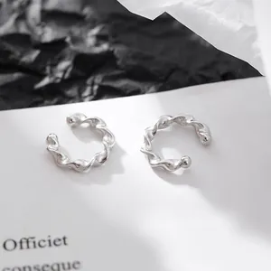 Gros plan de boucles d'oreilles mobius argentées sur un fond contrasté noir et blanc