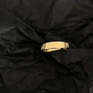 Minimalistischer S925 vergoldeter Ring mit Baumrindentextur auf schwarzem Papierhintergrund
