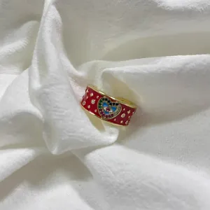 Dettaglio dell'anello in smalto rosso con cuore, zirconi colorati e motivi di stelle