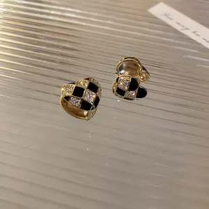 Detailed view of heart earrings with black and white checkerboard zircon inlay