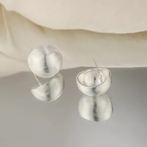 Orecchini a lobo semisferici in argento opaco con texture metallica spazzolata premium