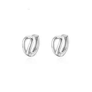 Dettaglio di orecchini a doppio strato a forma di C in argento dal design intrecciato