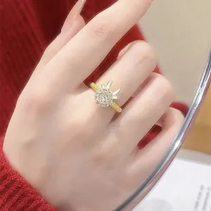 Detailed view of a golden bunny-shaped spinning ring with zircon stones and woven band