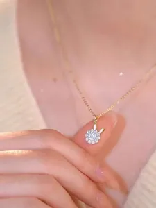 Close-up of a golden necklace with a sparkling diamond-encrusted rabbit pendant on skin
