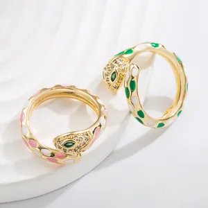 Detail of adjustable gold snake rings with colorful enamel dots and micro-set crystals