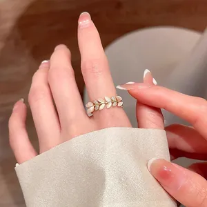 Primo piano di un anello a tulipano dorato con foglie di opale e piccoli cristalli