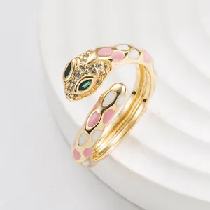 Punk style snake open ring with pink enamel spots and zircon crystals in gold finish