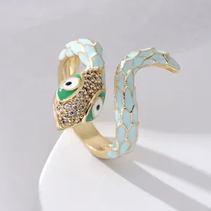 Detailed view of snake ring featuring light blue enamel scales and sparkling gemstone eyes