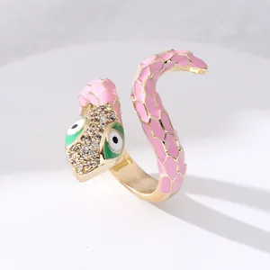 Macro shot of gold snake ring featuring pink enamel scales and pave crystal head detail