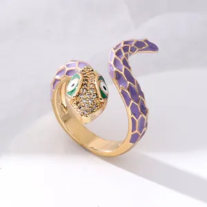 Detailed view of golden snake ring featuring purple enamel scales and white zircon head