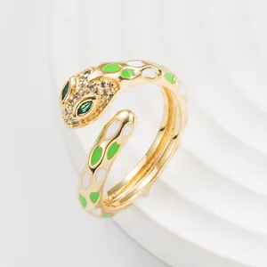 Macro detail of golden snake ring featuring green enamel patterns and sparkling zircon stones