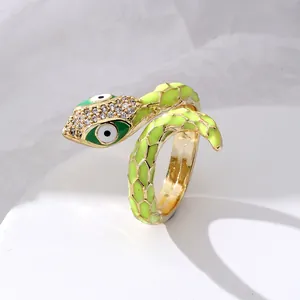 Close-up of gold-plated snake ring with green enamel scales and white zircon eyes
