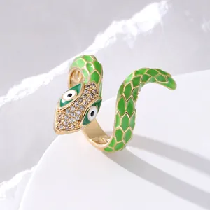 Close-up of golden snake ring with green enamel scales and white zircon head details