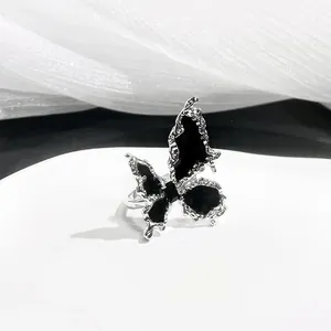 Minimalist adjustable silver butterfly ring with black oil drip and lava texture