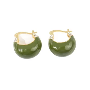 Orecchini a cerchio vintage in oro con smalto verde e cristalli su fondo bianco
