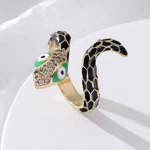 Adjustable snake ring in gold finish with black enamel scales and green eye details