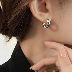 Boucles d'oreilles argentées à texture martelée irrégulière portées par un mannequin