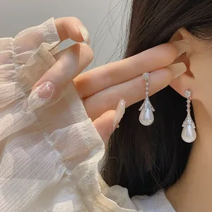 Eleganti orecchini a fiocco con perle a goccia e cappucci di petali luccicanti