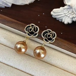 Elegant camellia stud earrings with black enamel flower and hanging champagne pearl charm