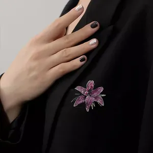Macro detail of luxury purple floral brooch with full diamond inlay on a black blazer