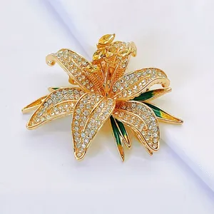 Detailed close-up of lily brooch with sparkling rhinestones and green enamel on satin