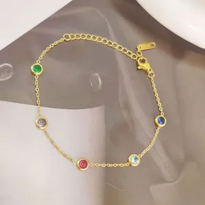 Close-up of 18K gold bracelet with five colorful round-cut zircons and K18 hallmark tag