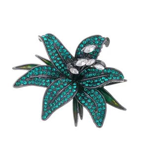 Elegant lily flower brooch featuring emerald green crystals and white marquise stones