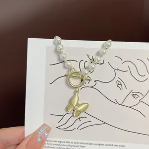 Detail of camellia pearl necklace featuring a yellow butterfly pendant and vintage OT buckle