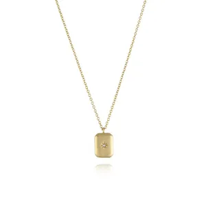 Detailed view of a gold rectangular pendant featuring a starburst engraving and zircon