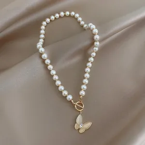 Detail of camellia pearl necklace with gold butterfly pendant and toggle clasp closure