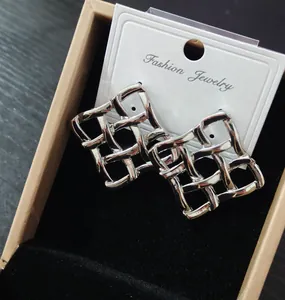 Dettaglio di orecchini a rete in argento in una confezione regalo con cartoncino